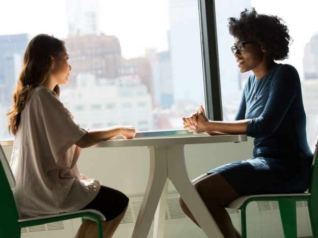 Parent and teenage child sitting at a table talking during exam time