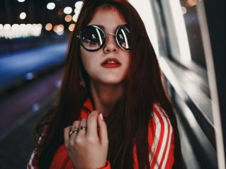 Teenager wearing trendy sunglasses, expressing personal confidence.