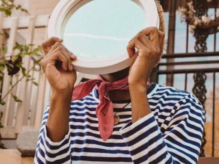 Young person holding a mirror in front of their face