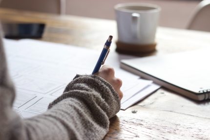 person sitting at desk writing notes